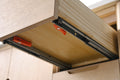 Underside view of VanityArt vanity drawer showing soft-close undermount drawer slide hardware with orange clips