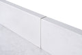 Close-up edge profile of white engineered stone backsplash and countertop with subtle marble veining
