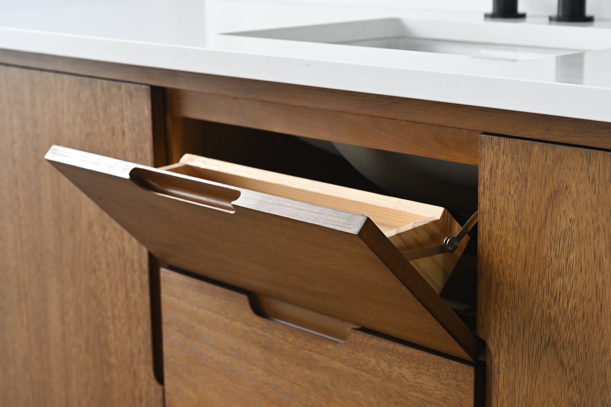 Close-up of tilt-out top drawer open showing angled wooden tray on walnut bathroom vanity
