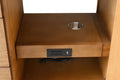 Interior shelf of walnut vanity cabinet showing built-in power outlets, USB port, and cord grommet