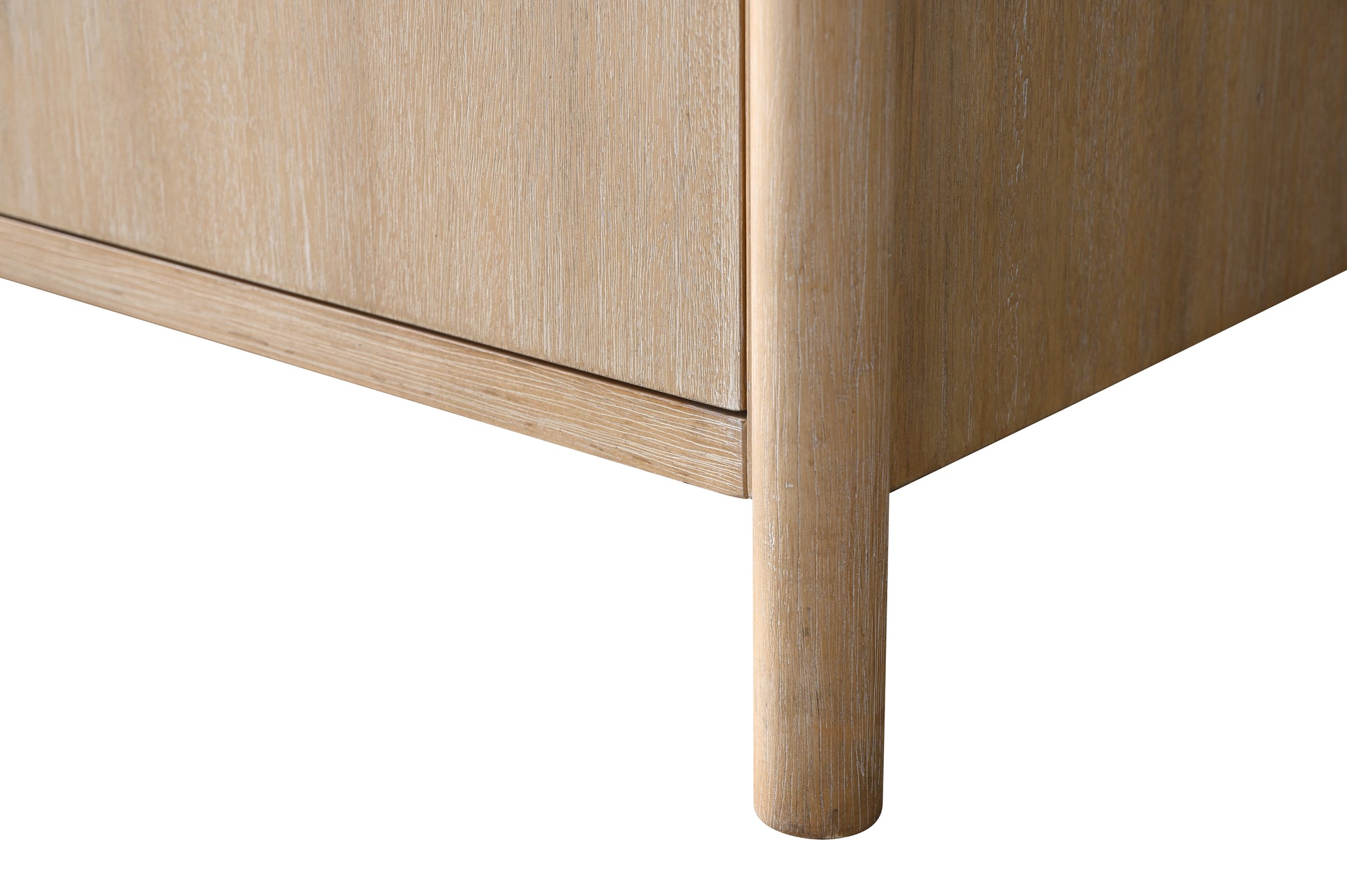 Close-up of bottom corner of light oak bathroom vanity showing tapered round leg and vertical wood grain